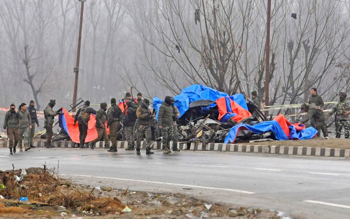 Security personnel inspect the blast site in Pulwama. 