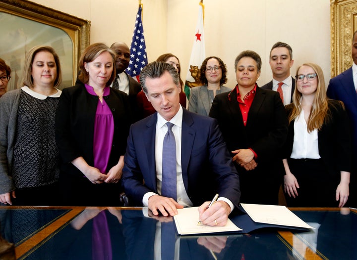 Gov. Gavin Newsom signs the executive order placing a moratorium on the death penalty at his Capitol office Wednesday, March 13, 2019, in Sacramento, Calif. 