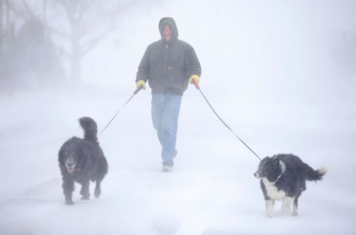 Tom Skaar of Cheyenne laughs while walking his dogs on House Avenue during a blizzard on Wednesday, March 13, 2019, in Cheyenne, Wyo. (Jacob Byk/The Wyoming Tribune Eagle via AP)