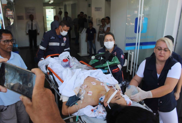 A teenager who was injured during a shooting inside the Raul Brasil State School, is carried on a gurney into a hospital, in