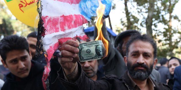 Un iraní quema un dólar como protesta por las nuevas sanciones de