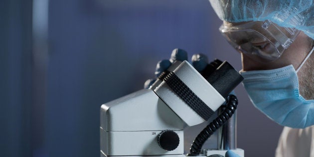 Un científico emplea un microscopio.