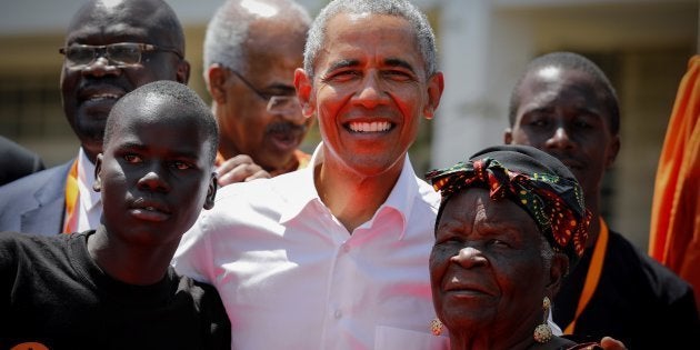 El expresidente estadounidense Barack Obama posa junto a su abuelastra Sarah Onyango Obama (derecha) y un estudiante durante la ceremonia de bienvenida del Centro de Formación Profesional y Deportiva Sauti Kuu en Kogelo.