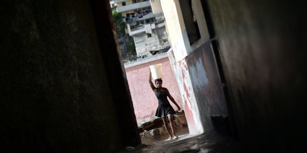 Una mujer lleva un cesto en un callejón de Puerto Príncipe, la capital de Haití.