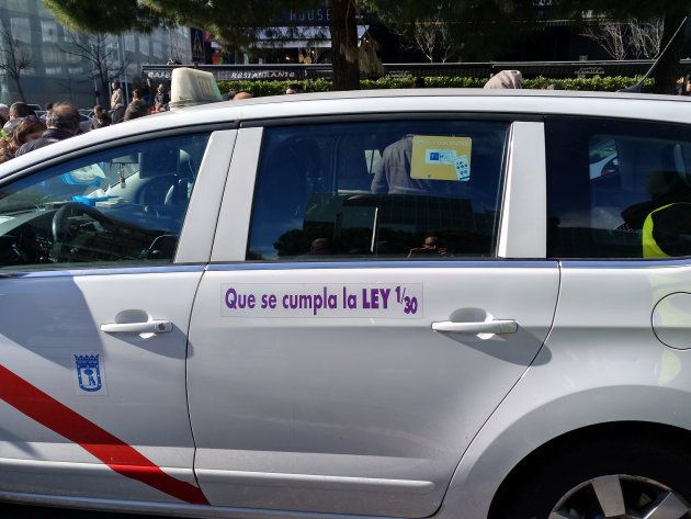 Un taxi con una pegatina que pide el 1/30 en la protesta frente al IFEMA.