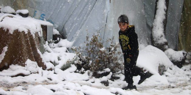 Un niño camina bajo la nieve en un campo de refugiados cerca de Burayqah, el pasado 26 de enero.