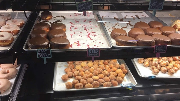 A rack of doughnuts for sale, including a sold-out tray for CBD doughnuts, at Glazed & Confuzed in Aurora, Colorado. Rest