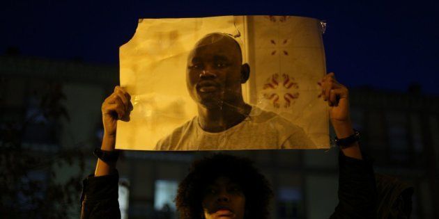 Una joven alza la foto de Mame Mbaye durante una concentración antirracista en Lavapiés.