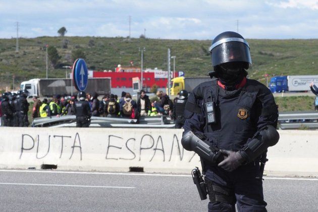 Antidisturbios montan guardia después de que la Policía rompiera una barricada en la autopista A-47 de independentistas catalanes, cerca de Figueras, como protesta por la detención de Puigdemont