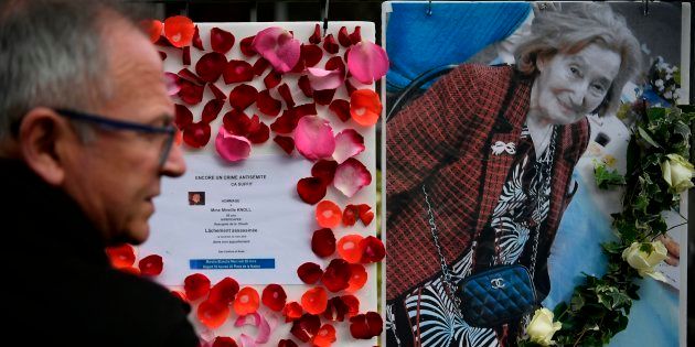 Un hombre pasa ante la foto de Mireille Knoll y los mensajes que convocan a una marcha en su memoria, ante su casa de París.