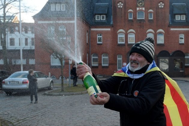 Un hombre con una bandera estelada celebra con champán frente la cárcel de Neumünster, donde permanece recluido el expresidente catalán Carles Puigdemont, en Alemania, hoy, 5 de abril de 2018. La Audiencia Territorial de Schleswig-Holstein, en el norte de Alemania, ha descartado hoy el delito de rebelión en la petición de extradición a España de Puigdemont y lo ha dejado en libertad bajo fianza mientras estudia la entrega por malversación.
