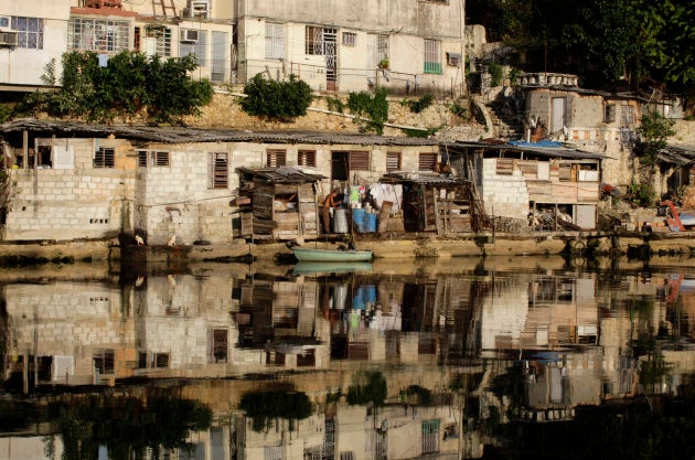Un hombre barre la puerta de su casa en el barrio de Almendares, en La Havana.