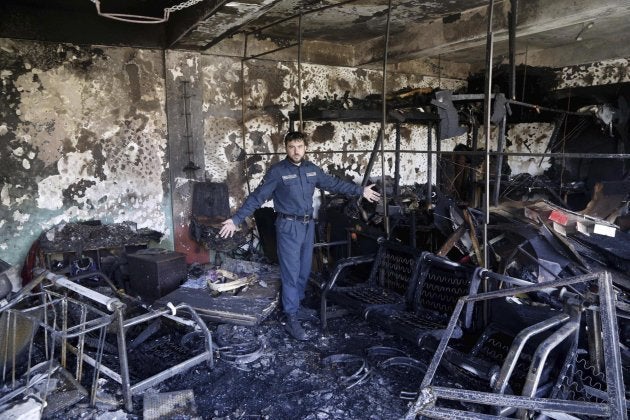 Un efectivo de las fuerzas de seguridad inspecciona el lugar tras el atentado suicida perpetrado en Kabul.