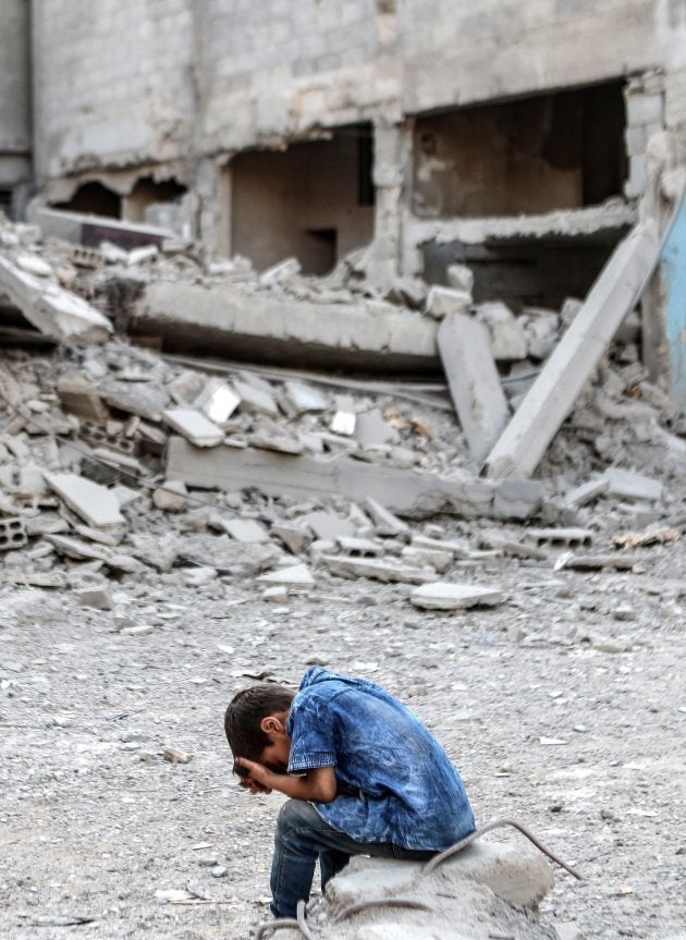 Un niño se sienta desesperado frente a una mezquita destrozada por los bombardeos de ayer martes en Arbin, a la afueras de Damasco.