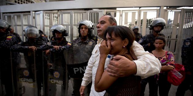 Miembros del partido de Fernando Albán se abrazan frente al edificio del Sebin, desde el que cayó su cuerpo.