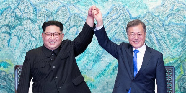 El presidente surcoreano Moon Jae-in y el líder norcoreano Kim Jong-un estrechan y alzan sus manos.