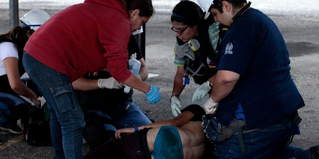 Sanitarios asisten a una persona herida durante un enfrentamiento entre manifestantes opositores y la...