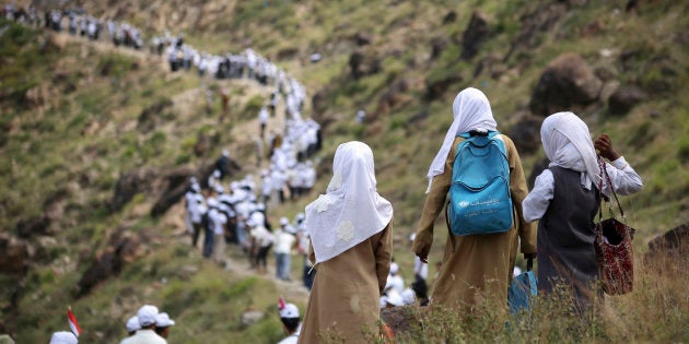 Voluntarios yemeníes forman una cadena humana para transportar la ayuda alimentaria que envía la Media Luna Roja.