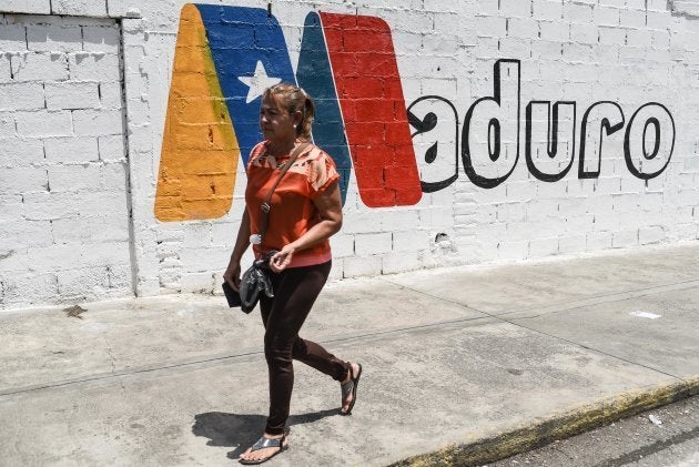 Una mujer pasa ante un mural de apoyo a Maduro en Charallave, estado de Miranda, el pasado 15 de mayo.