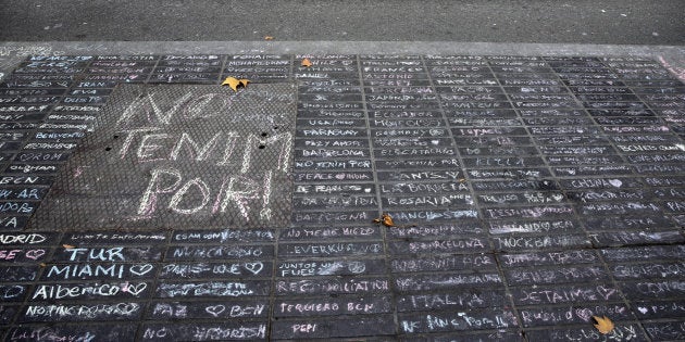 Un taxi pasa junto a los mensajes de apoyo escritos con tiza en una acera de Las Ramblas de Barcelona.