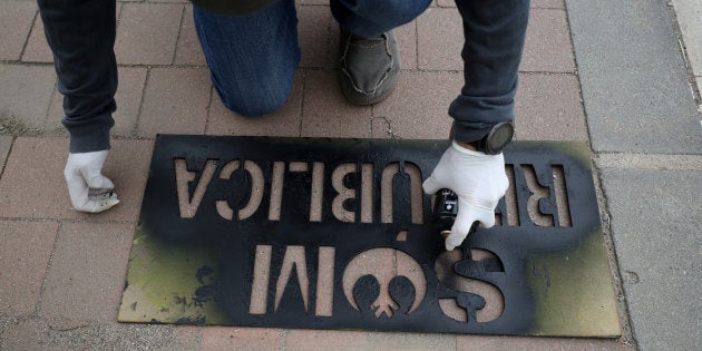 Un miembro de los Comités de Defensa de la República (CDR) en Granollers estampa una plantilla en la...