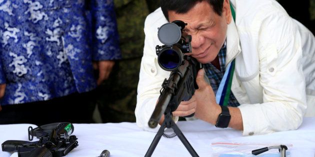 El presidente filipino, Rodrigo Duterte, chequea un rifle cedido por China, el pasado junio cerca de Ángeles City.