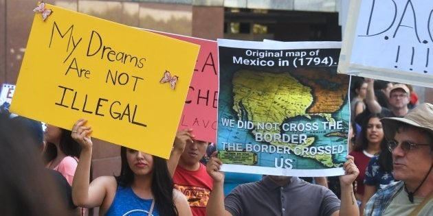 Dos 'dreamers' enarbolan pancartas en favor del programa que los protege de ser expulsados: el amarillo