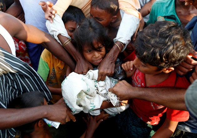 Un grupo de refugiados rohingya pugna por la comida que varias ONG les han llevado tras tocar tierra bangladeshí en Teknaf.