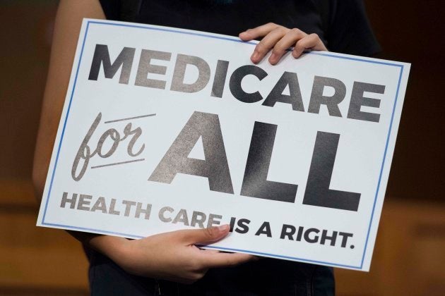 Un miembro del público sujeta una pancarta con el lema de Sanders para una sanidad universal