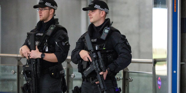 Dos policías armados patrullan los alrededores del lugar del ataque.