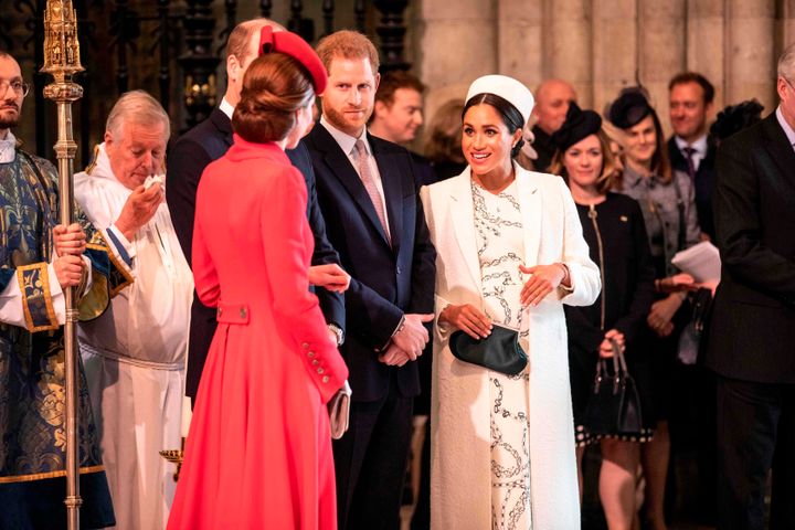 The Duchess of Cambridge (foreground) and Duchess of Sussex greet each other as they attend the Commonwealth Service with other members of the royal family at Westminster Abbey on March 11, 2019.