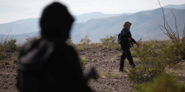 Police officers keep watch as members of civil and human rights organizations (not in picture) search for the remains of women who have gone missing, in Juarez Valley, Mexico, October 22, 2016. REUTERS/Jose Luis Gonzalez