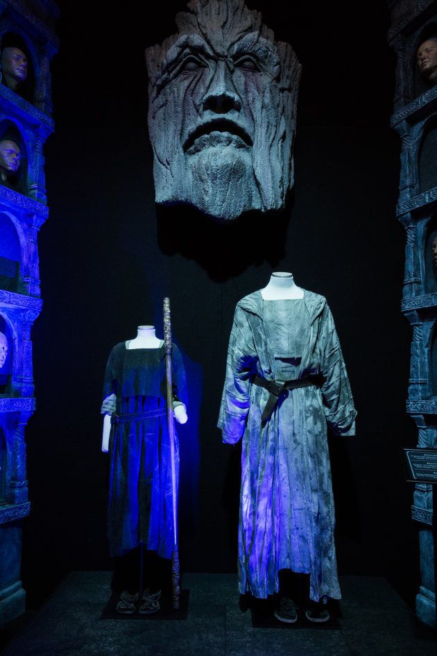 Los trajes de Arya y Jaqen, bajo la efigie de uno de los dioses de los Hombres Sin Rostro y junto a varias caras.
