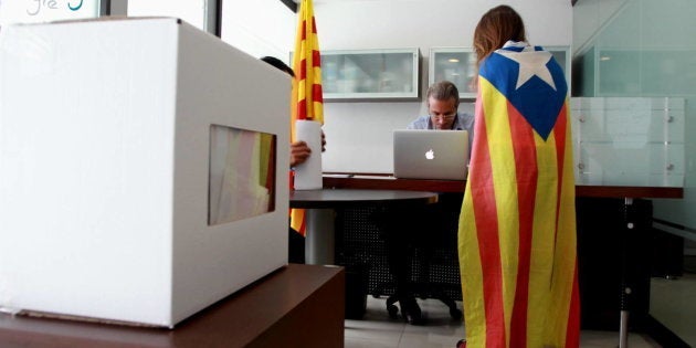 Una joven con una estelada sobre los hombros vota la consulta del 9 de noviembre de 2014.