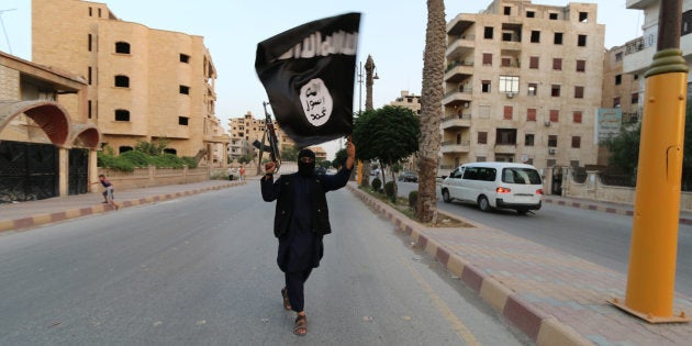Un miembro del Estado Islámico enarbola su bandera en la ciudad siria de Raqqa, en junio de 2014.