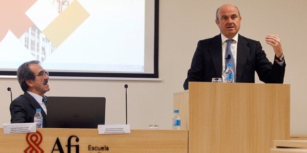 El ministro de Economía, Luis De Guindos, bajo la atenta mirada del presidente de Analistas Financieros Internacionales, Emilio Ontiveros, en la sede de AFI. EFE/Álvaro Sánchez