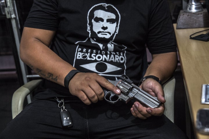 A customer wearing a shirt in support of Brazilian President Jair Bolsonaro views a Forjas Taurus SA firearm for sale at a gun shop in São João de Meriti, Brazil.