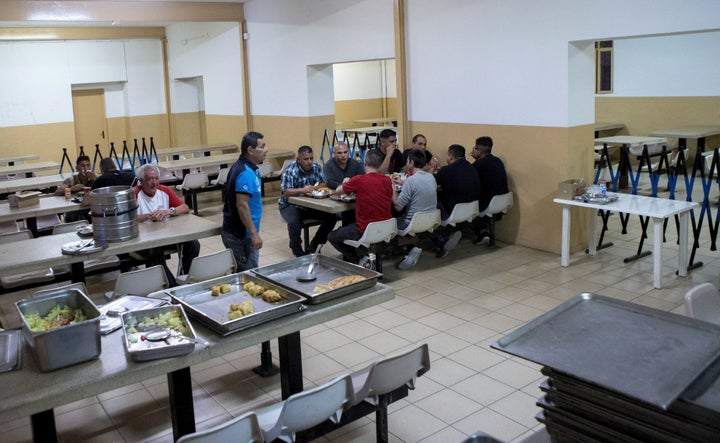 Varios de los 24 presos que han pasado la última noche en la cárcel Modelo de Barcelona, antes de que este centro penitenciario cierre definitivamente sus puertas, tras cumplir 113 años de historia. Los presos cenaron un menú poco habitual en un centro penitenciario, integrado por gazpacho, ensalada, pizza y helado, antes de retirarse a las celdas a pasar la noche