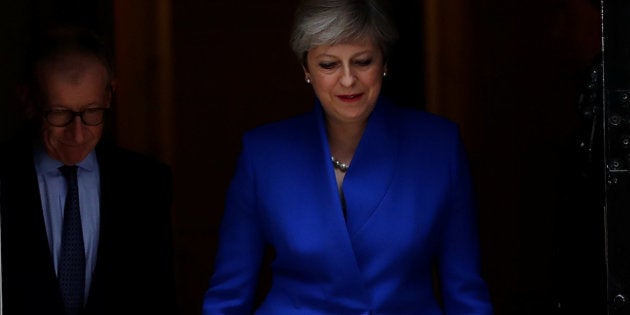 Theresa May, vestida de azul conservador, sale de la residencia oficial para ir a ver a la reina Isabel.
