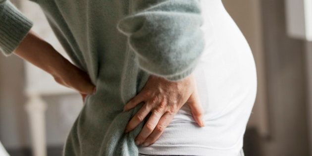 Pregnant woman holding back in pain
