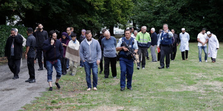 Survivors are escorted from the scene by police.