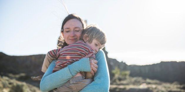 A mother holds her young son to comfort him after falling down whild hiking on the trails at Frenchmans Coulee in Eastern Washington.