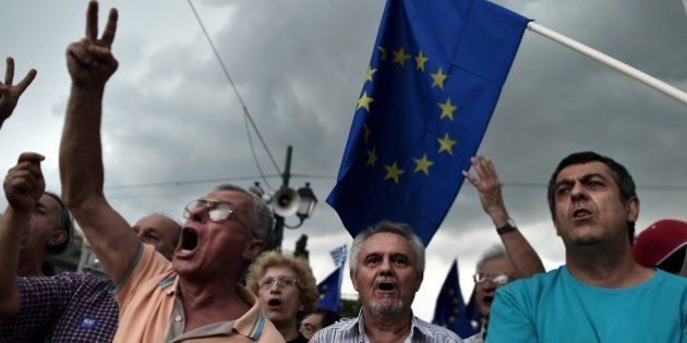 Pro-euro protesters hold European Union flags during a demonstration in front of the parliament in Athens on June 30, 2015. European leaders want to 'sink' Greece's ruling Syriza party to block the rise of other far-left, anti-austerity parties such as Podemos in Spain, Greece's Labour Minister Panos Skourletis said Tuesday. AFP PHOTO / ARIS MESSINIS (Photo credit should read ARIS MESSINIS/AFP/Getty Images)