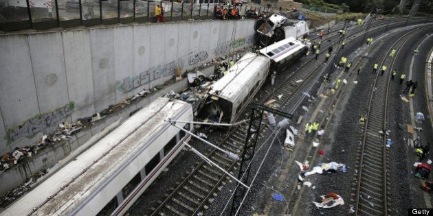 Rescuers, forensics and police officers work at the site of a train accident near the city of Santiago...