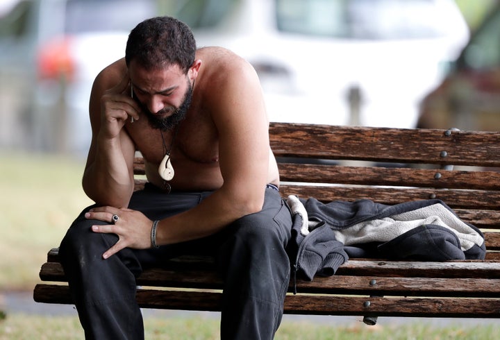 A distraught survivor of the attack makes a call outside the scene.