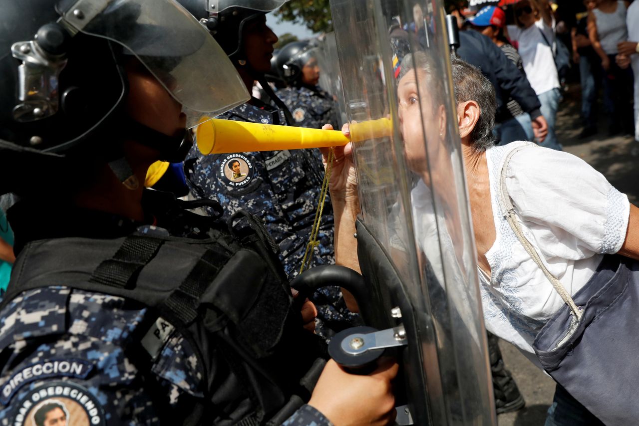 An opposition protester confronts a police officer at a rally against Venezuelan President Nicolás Maduro's government in Caracas, Venezuela, on March 9, 2019.