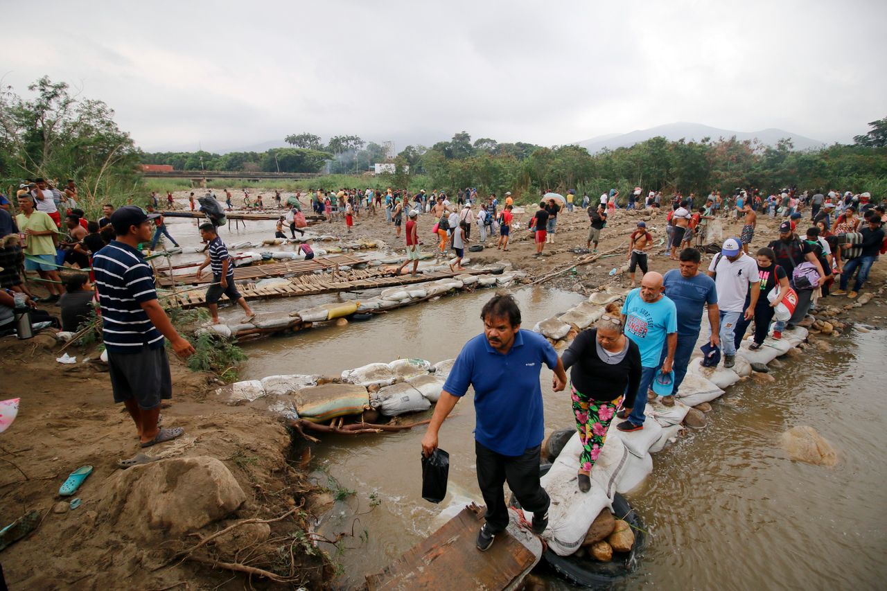 People cross the Tachira River near the Simon Bolivar International bridge on the Colombia-Venezuela border, March 12, 2019. People crossing the river are using makeshift bridges as the water level grows with the approaching rainy season.