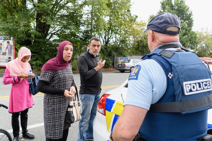 People concerned about the fate of their relatives talk to police outside the Al Noor mosque in Christchurch, New Zealand, on