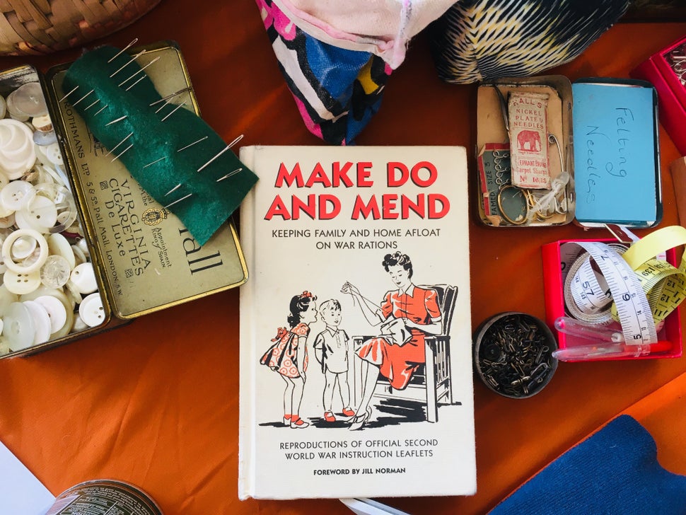 Sarah Klymkiw's fashion repair table, complete with needles, buttons, spare bits of fabric and a vintage guide to mending. Th