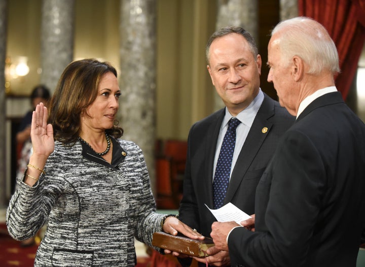 Vice President Joe Biden administers the Senate oath of office to Kamala Harris as her husband, Douglas Emhoff, holds the Bib